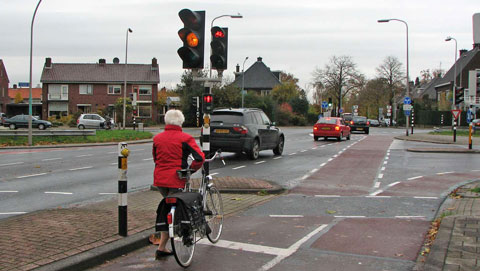 fietser voor rood stoplicht. voor auto's oranje